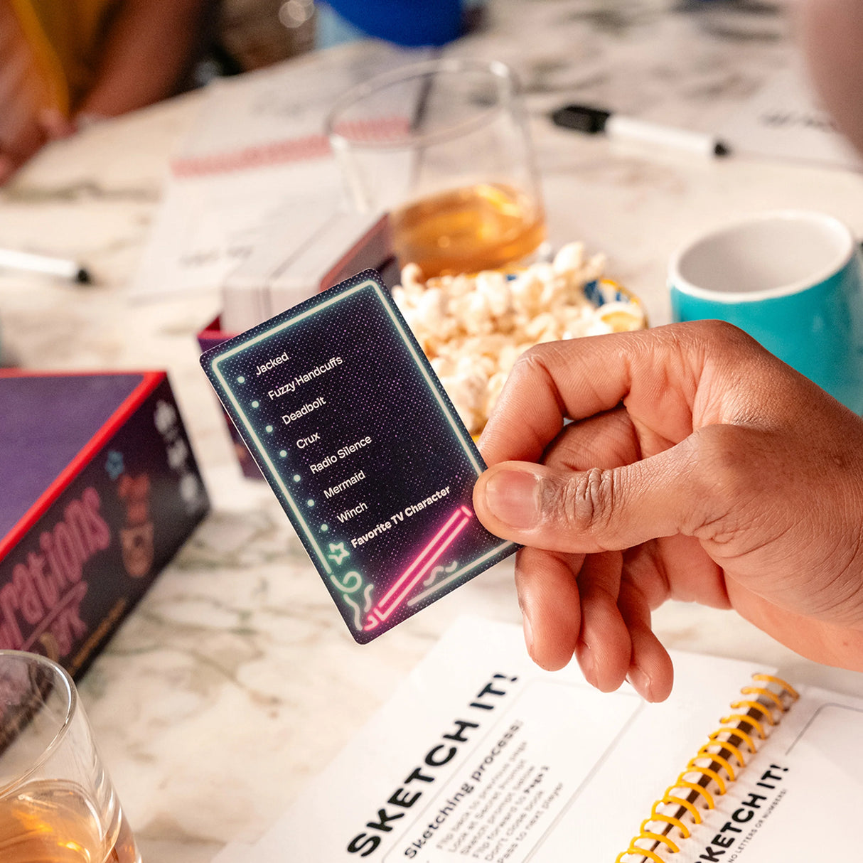 Telestrations After Dark 8 Player (2nd Edition) board game players laughing and drawing