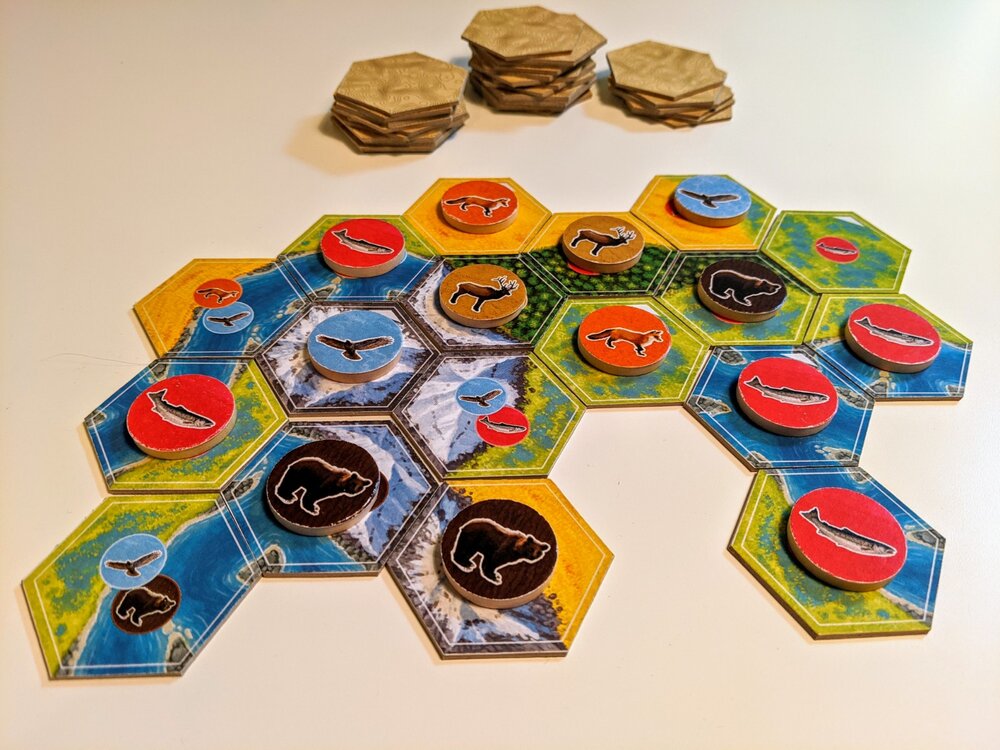 Cascadia board game hexagonal tiles with wildlife tokens and natural landscapes